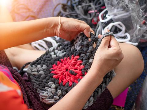 someone working on braiding t-shirt material into a rag rug