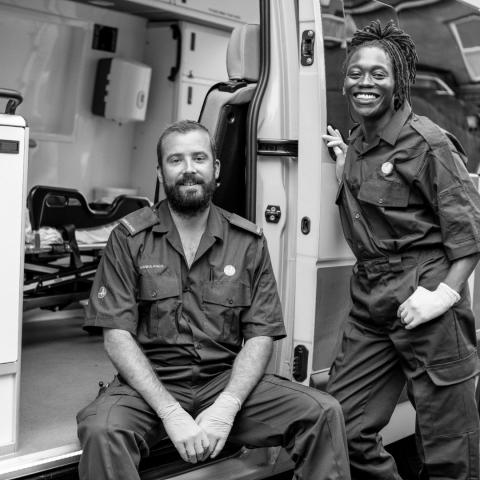 Two paramedics next to an ambulance.