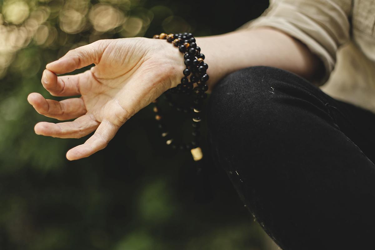 Person holding hand in meditation pose